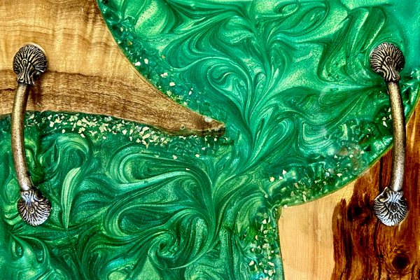 An epoxy river tray consisting of a vivid green-pigmented UltraClear Art & Craft Epoxy river vein, two pieces of wood, and two metal handles attached to it.