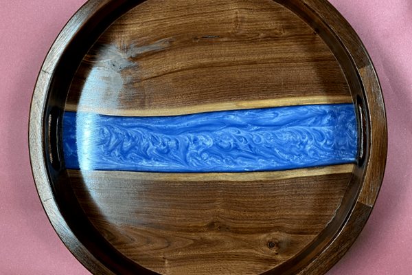 A wooden epoxy river tray made using walnut wood and UltraClear Deep Pour Epoxy. It features a blue-pigmented river vein and wooden handles.