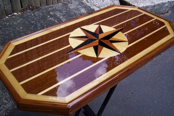 A small epoxy table top featuring a transparent UltraClear Bar & Table Top Epoxy finish. The substrate is wood and showcases an image of a compass rose in the center.