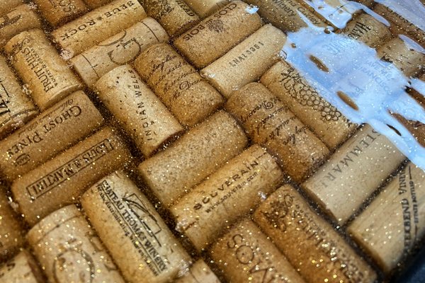 An epoxy end table with an embedded layer of wine corks, finishing up a curing phase.
