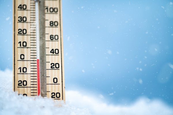 Photo of a thermometere propped up by snow.