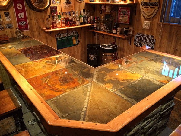 A tile epoxy bar top with a high wooden trim.