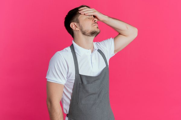 A man putting holding his hand to his forehead in frustration.