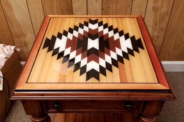 A wooden end table with an UltraClear Bar & Table Top Epoxy finish. It has one small drawer and is square in shape.