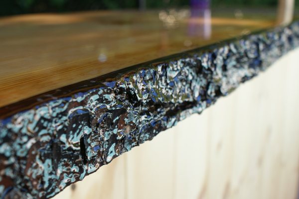 A close-up view of the live-edge side of an epoxy DIY bar top. It's been sealed with UltraClear Bar & Table Top Epoxy.