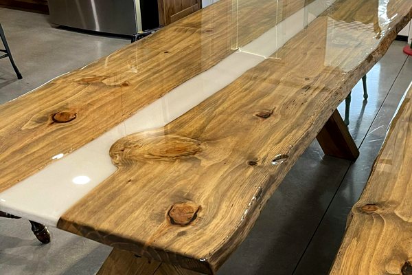 A large epoxy river table with a white-pigmented river vein made of UltraClear Deep Pour Epoxy. The table has been topcoated with UltraClear Bar & Table Top Epoxy for long-lasting, crystal-clear protection.