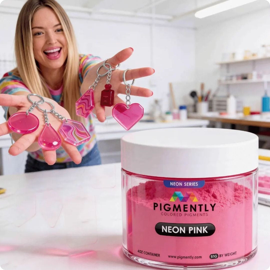 Ilona holding pink heart-shaped keys with a container of powder pigment Neon Pink powder in a workshop setting.