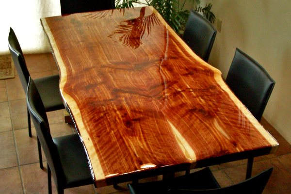 A wooden epoxy dining table with slightly smoothed live edges. It's been sealed with UltraClear Bar & Table Top Epoxy.