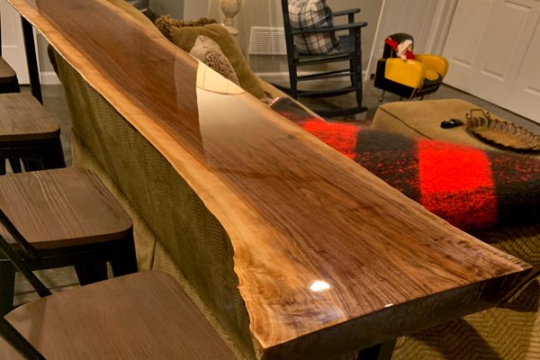 A long live-edge wooden console table with an UltraClear Bar & Table Top Epoxy finish.