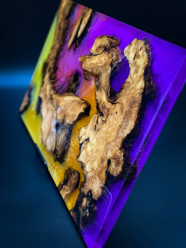 A piece of epoxy art incorporating several different pigments and live edge wood slabs