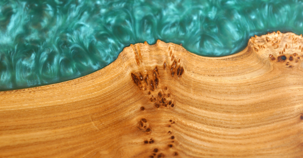A close-up view of a wooden epoxy river table's epoxy vein