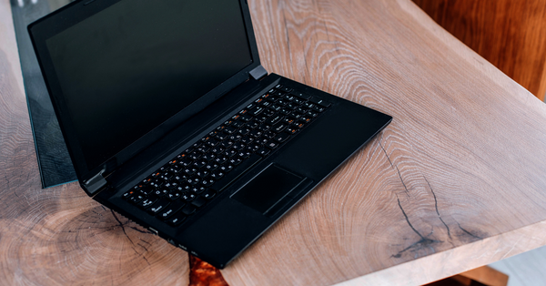 A laptop on an unfinished wooden slab