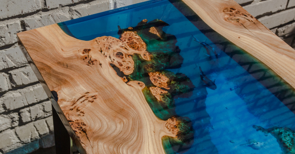 An epoxy river table with a wide, blue-pigmented epoxy vein