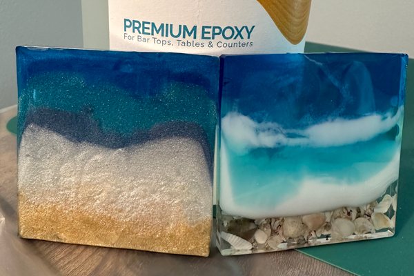 Two epoxy resin coasters, each with a different ocean-style theme. They were made using UltraClear Epoxy along with blue and white pigments and some beach-themed embements.