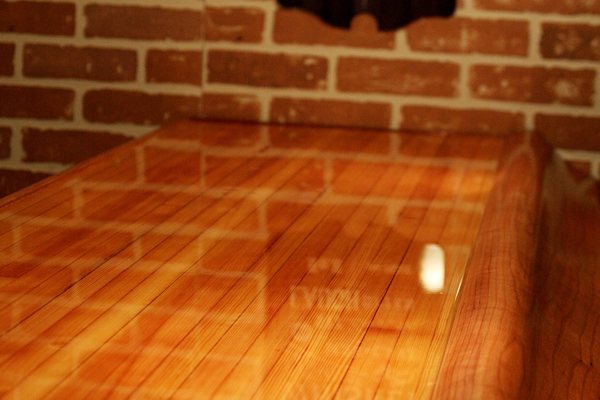 A wooden bar top with a smooth, crystal-clear epoxy finish. It was made using UltraClear Bar & Table Top Epoxy.