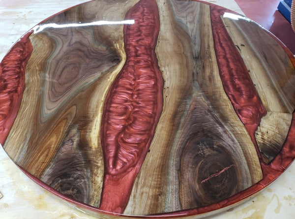 A deep pour epoxy river table with red veins