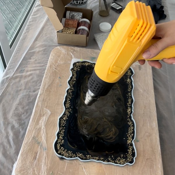 An epoxy heat gun being used on a freshly poured resin layer.