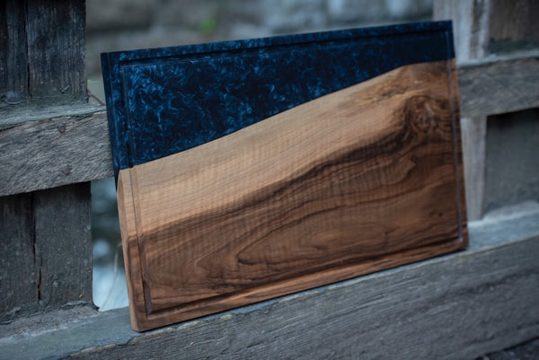 An epoxy charcuterie board with a deep ocean blue hue