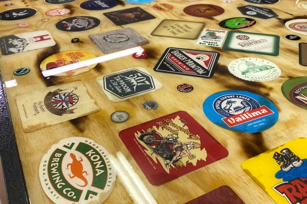An epoxy bar top with a variety of embedded beer-brand coasters. The bar has been finished with UltraClear Bar & Table Top Epoxy.