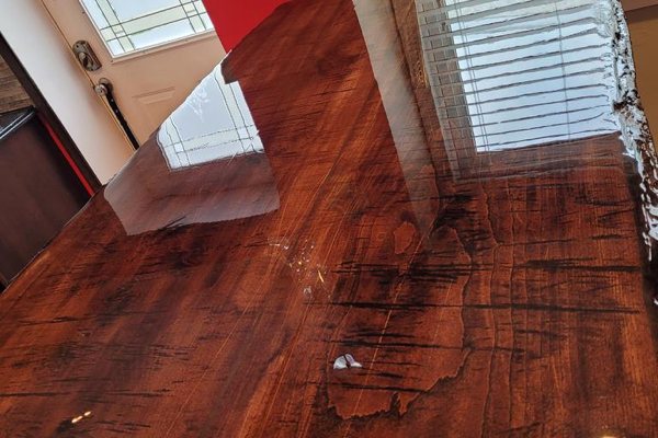 A live-edge wooden epoxy dining table with a crystal-clear UltraClear Bar & Table Top Epoxy finish.
