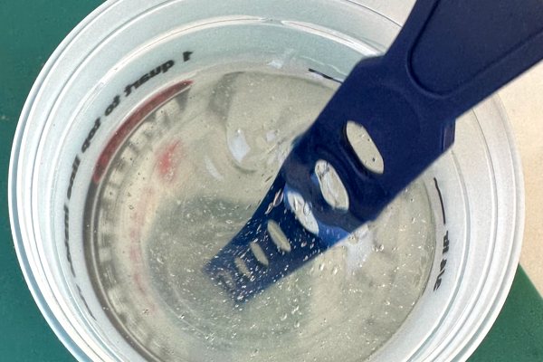 A small batch of epoxy being mixed by hand using a plastic stir stick.