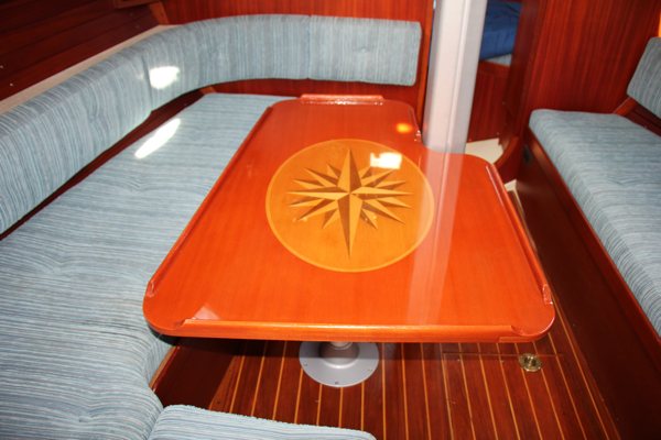 A wooden table top painted bright orange and featuring imagery of a compass rose. It has been sealed with UltraClear Bar & Table Top Epoxy, which provides a long-lasting, waterproof finish that is highly durable.