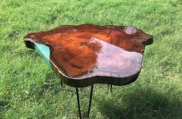 A photo of a small epoxy table top. It has a clear-coat epoxy finish with a small patch of pigmented epoxy on one side, adjacent to the wooden substrate.