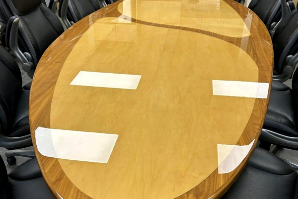 A large oblong wooden conference table with an UltraClear Bar & Table Top Epoxy finish.