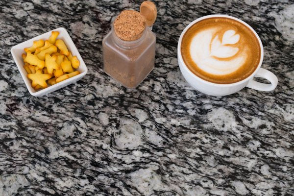 A granite-style epoxy table top with a a few dishes on top.