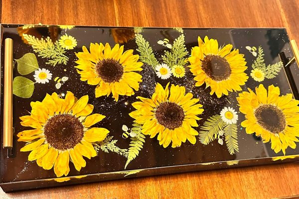 A resin tray with a variety of embedded flowers and leaves, made using UltraClear Art & Craft Epoxy.