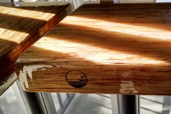 A wooden epoxy table top in a restaurant. It features an UltraClear Bar & Table Top Epoxy finish.