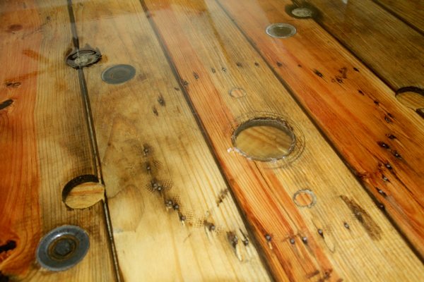 A close-up view of a wooden epoxy table top with a crystal-clear renewed coating of UltraClear Bar & Table Top Epoxy.