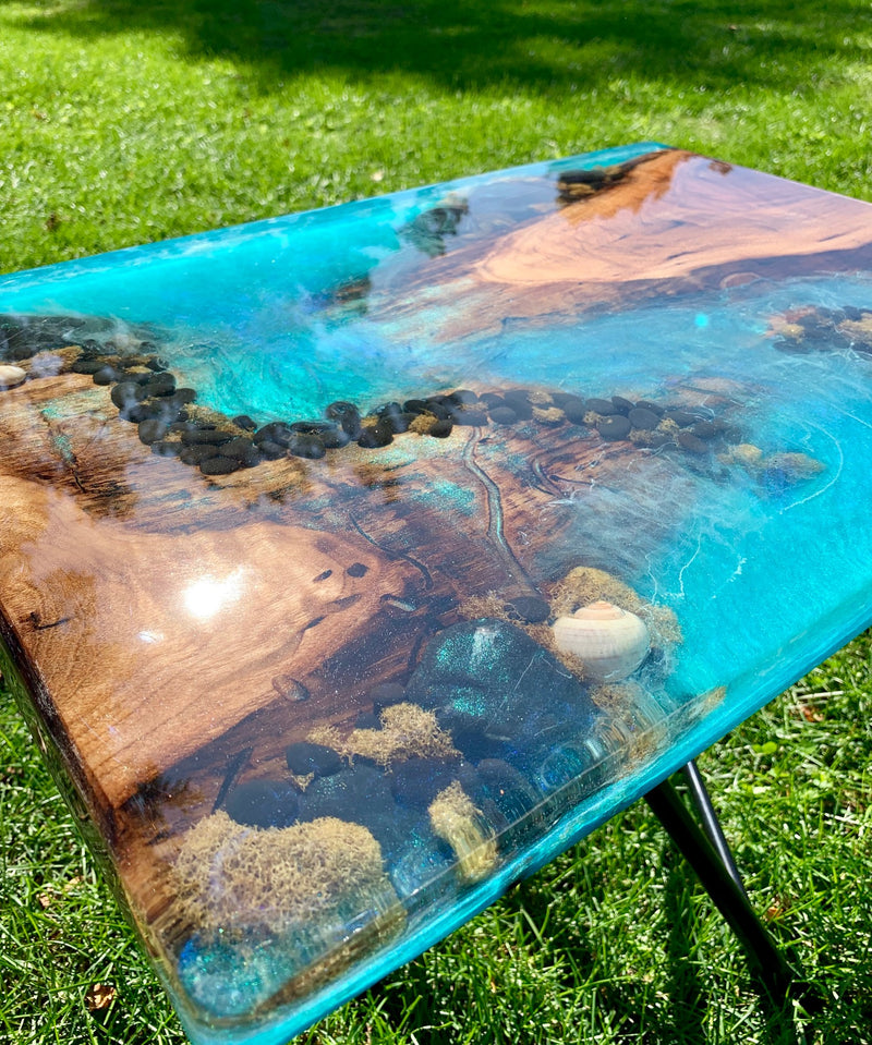 An epoxy river table with embedded rocks, shells, and more
