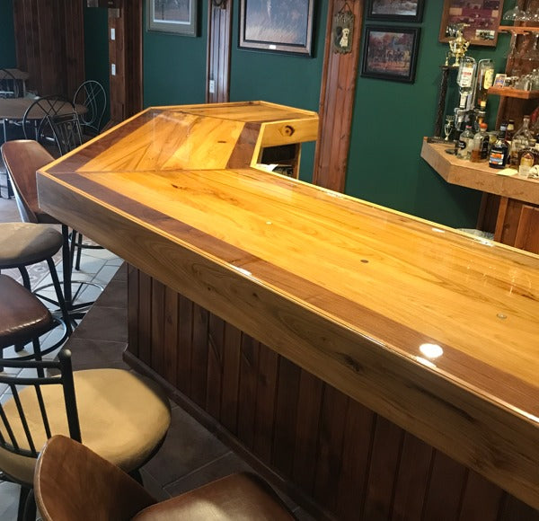 A wooden commercial bar top with a waterproof epoxy resin finish.