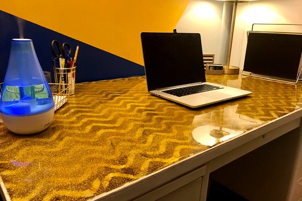 A desk with an UltraClear Bar & Table Top Epoxy finish atop a glittery, wavy substrate.