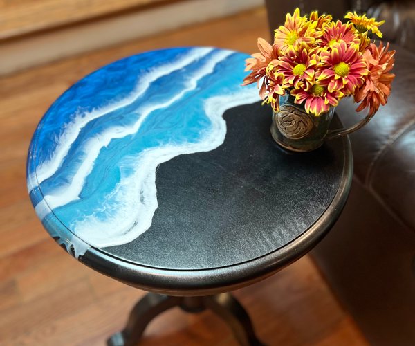 A small end table featuring a resin ocean art epoxy finish.
