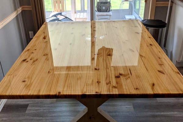 An old wooden dining table that has been restored with a pristine UltraClear Bar & Table Top Epoxy finish.