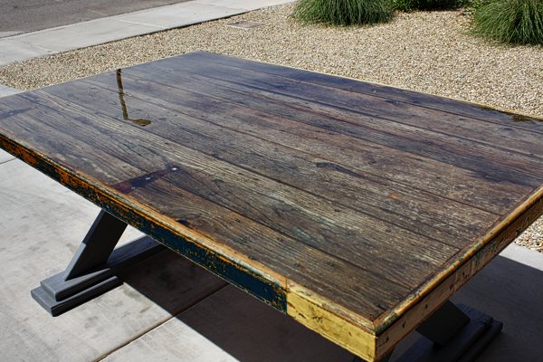 An outdoor rustic wooden epoxy table top. It has been sealed with UltraClear Bar & Table Top Epoxy, resulting in a smooth, transparent, rock-solid surface.