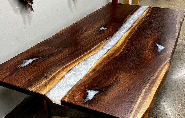 An epoxy river table with two beautiful medium-brown wood slabs and an opaque white river vein of UltraClear Deep Pour Epoxy running between them.