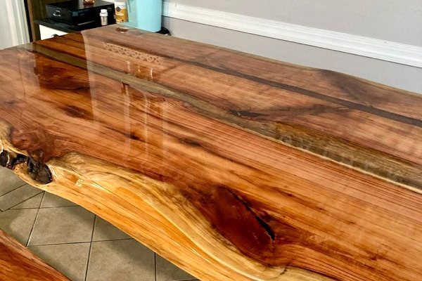 A live-edge wooden table top with an UltraClear Bar & Table Top Epoxy finish. The finish is crystal-clear and highly durable.