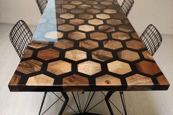 A large epoxy river table made using many hexagonal pieces of wood between which a thick black-tinted UltraClear Deep Pour Epoxy layer has been poured.