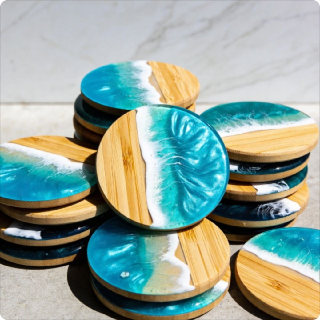 Stacks of coasters with blue and white wave design on a wooden base.
